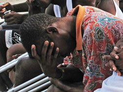 Haiti amputee soccer player prays.